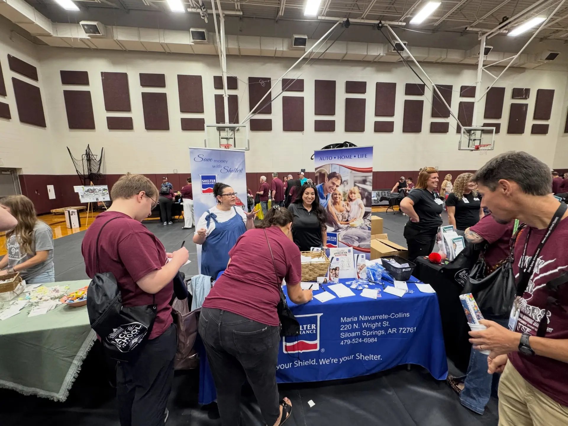 Agency team members talking with Siloam Springs teachers and staff at the insurance booth