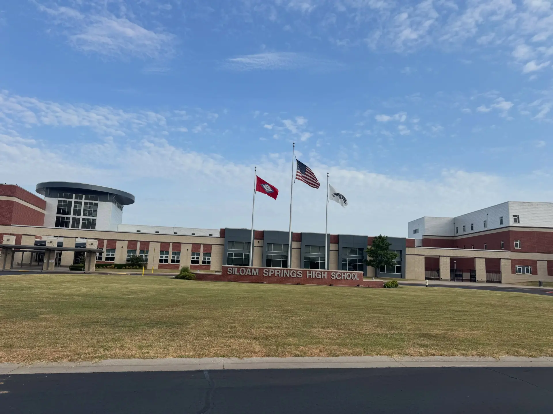 Siloam Springs High School building with flags flying out front
